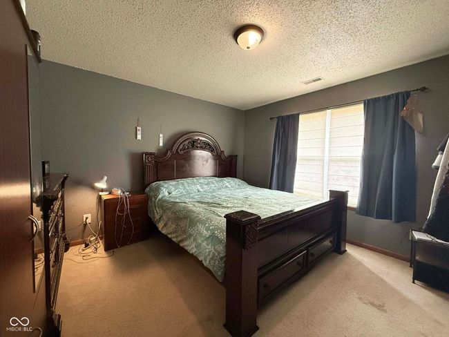 bedroom featuring light colored carpet and a textured ceiling | Image 15
