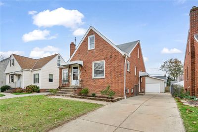 View of front of house featuring an outbuilding, a garage, and a front lawn | Image 2