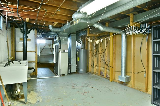 Unfinished basement with visible vents, heating unit, and water heater | Image 39