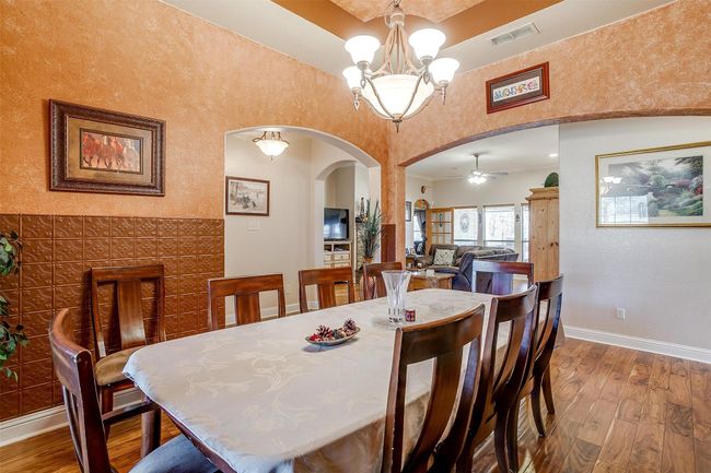 Dining room with arched walkways, visible vents, and hardwood / wood-style flooring | Image 7