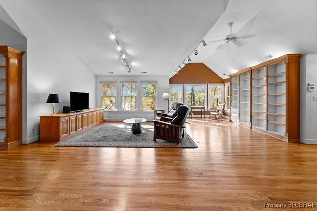 Living area with track lighting, vaulted ceiling, light wood finished floors, and a ceiling fan | Image 38