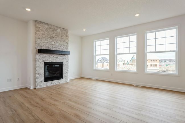 Photo is of the actual home. Cozy and contemporary, the main level great room comes with a stunning gas fireplace. | Image 5