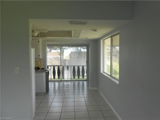 Hall with light tile patterned flooring and baseboards | Image 7