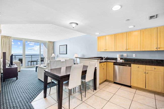 Kitchen with a peninsula, light brown cabinetry, visible vents, and dishwasher | Image 5