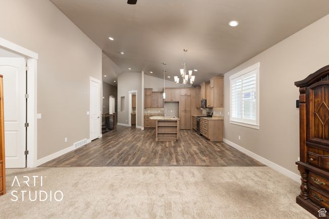 Kitchen featuring dark carpet, stainless steel electric range, a chandelier, recessed lighting, and vaulted ceiling | Image 21