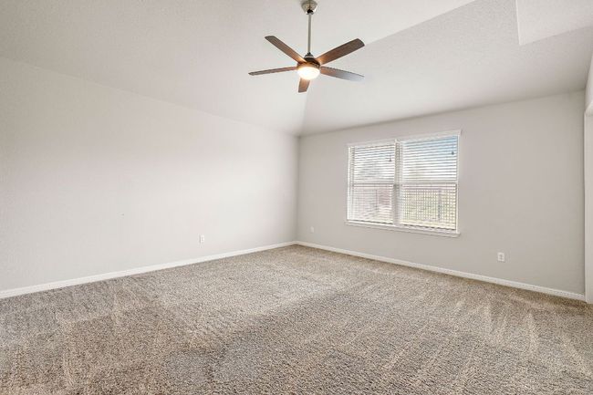 Unfurnished room featuring lofted ceiling, a ceiling fan, baseboards, and carpet floors | Image 16