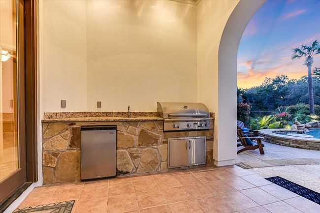 Patio terrace at dusk featuring area for grilling with sink and outdoor mini fridge | Image 34