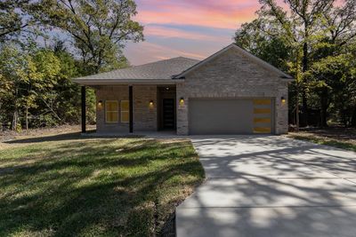 View of front of home featuring a garage and a lawn | Image 1