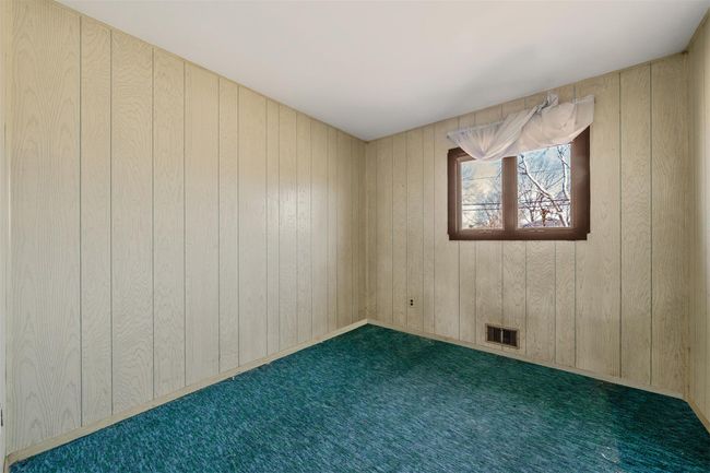 Spare room featuring carpet floors, visible vents, and wood walls | Image 18