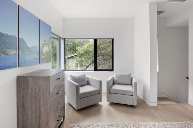 Sitting room featuring light wood-type flooring, a water view, and baseboards | Image 37