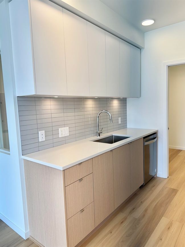 Kitchen with a sink, stainless steel dishwasher, tasteful backsplash, and light wood-style floors | Image 8