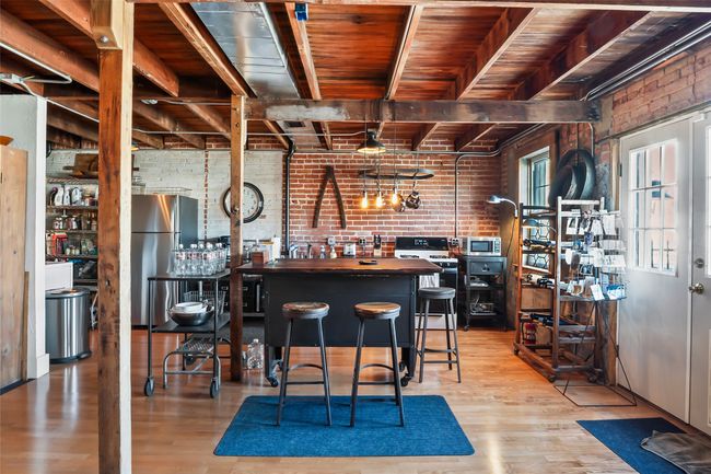 Bar with stainless steel appliances, wood finished floors, wooden ceiling, and brick wall | Image 15