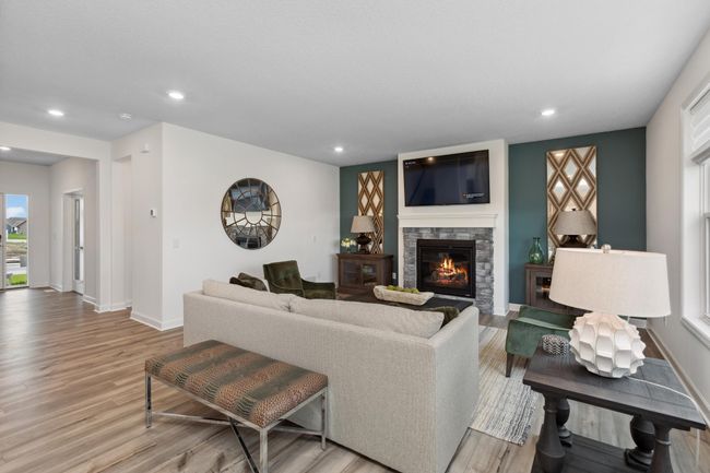 Photo is of the actual model. The spacious living room seamlessly connects to the kitchen area, perfect for entertaining. It also features many large windows providing warm natural light. | Image 6