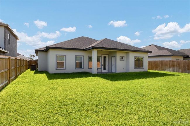 Back of house with a fenced backyard, stucco siding, and roof with shingles | Image 18