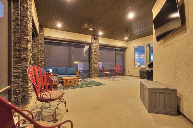 The screened-in porch offers a year-round retreat, perfect for unwinding in comfort. Featuring a warm tongue and groove ceiling, stone accents, and ample space for seating, this inviting area combines style and relaxation with beautiful outdoor views. | Image 36