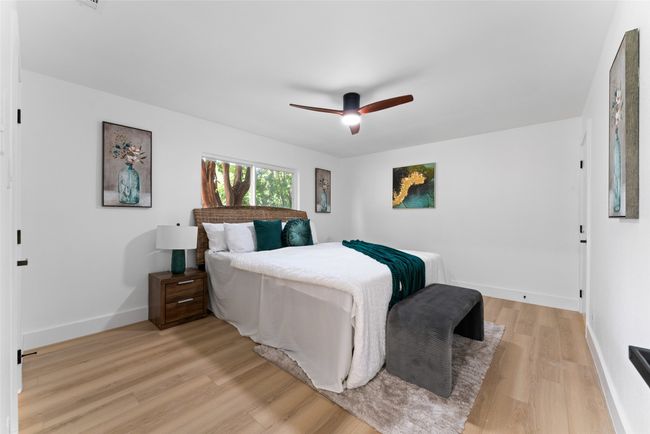 Bedroom with light wood-style floors and ceiling fan | Image 12