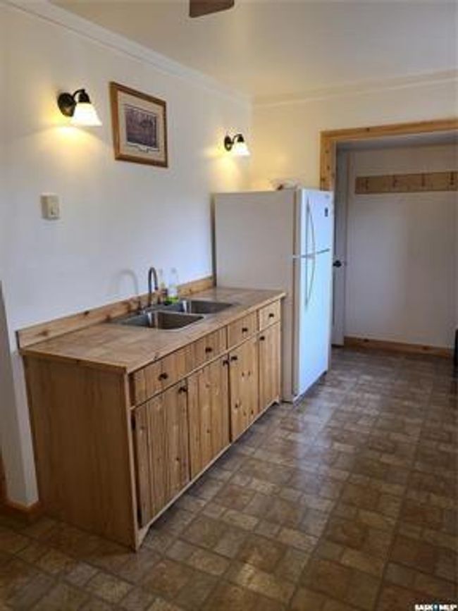 Kitchen with white refrigerator, crown molding, and sink | Image 21