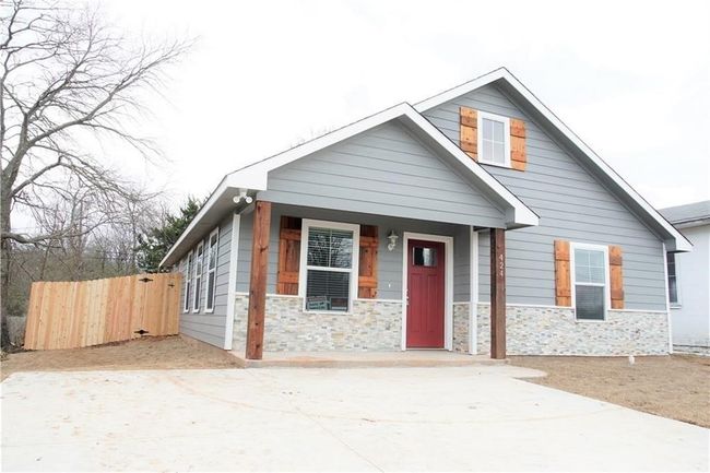 View of front of property with stone siding, concrete driveway, and covered porch | Image 21