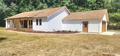 Ranch-style home with a garage, a porch, and a front lawn | Image 1