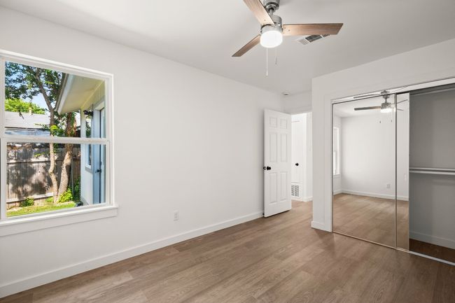 Unfurnished bedroom with wood finished floors, a closet, and ceiling fan | Image 15