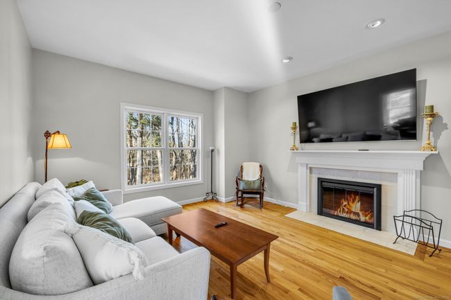 The family room offers hardwood floors, recessed lights, and a cozy gas fireplace for the colder months. | Image 12