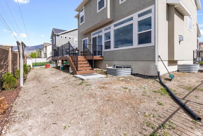 Back of house with stairs, a residential view, a deck, stucco siding, and fence | Image 29