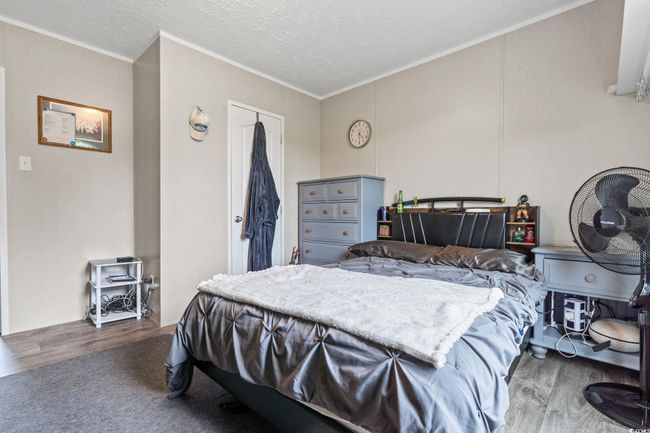 Bedroom with crown molding, wood finished floors, and a textured ceiling | Image 21