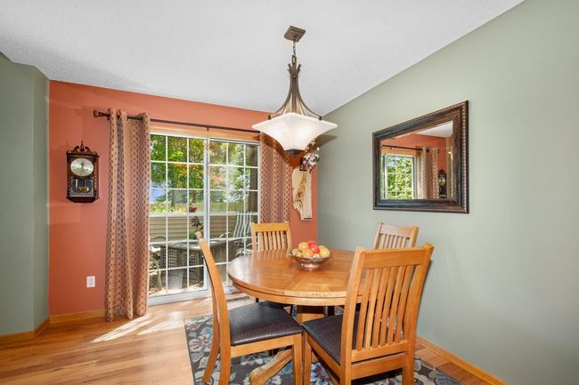 Dining area with sliding door to patio and view of the green space | Image 10