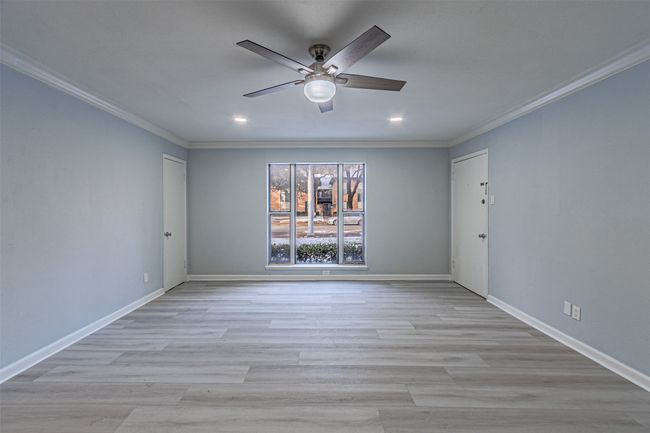 Spare room with crown molding, ceiling fan, and light wood-type flooring | Image 33
