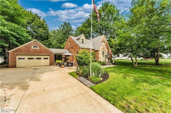 View of front of house with a front lawn, driveway, brick siding, and an attached garage | Image 4