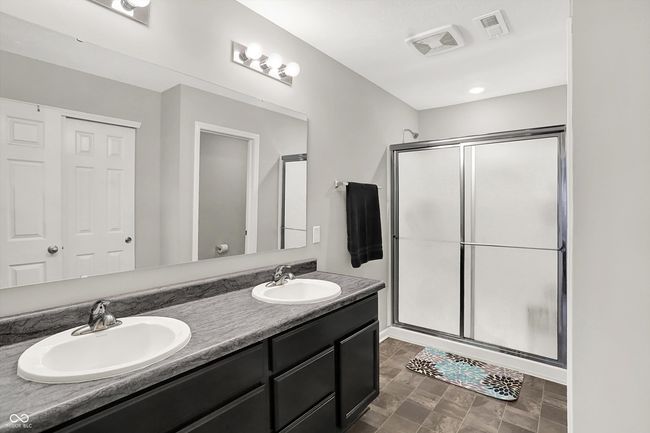 Primary bath has dual sinks, stand up shower, large linen closet and water closet. | Image 25
