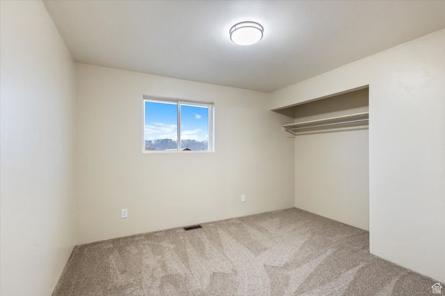 Unfurnished bedroom with carpet, visible vents, and a closet | Image 19