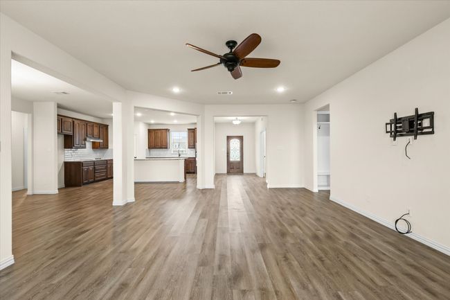 Unfurnished living room featuring a ceiling fan, wood finished floors, and recessed lighting | Image 13