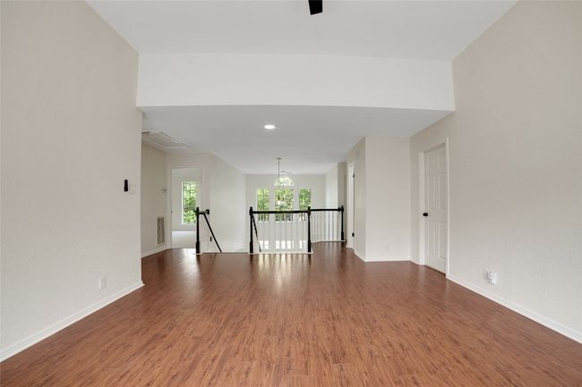 Lofted room with wood finished floors, baseboards, and attic access | Image 16
