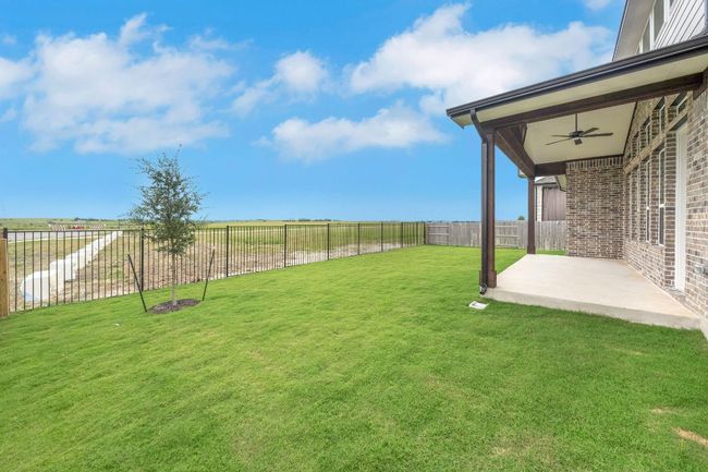Fenced backyard featuring a ceiling fan, a patio area, and a rural view | Image 24