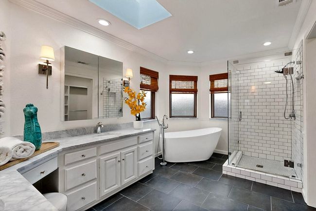 Bathroom with a soaking tub, a stall shower, vanity, crown molding, and a skylight | Image 20