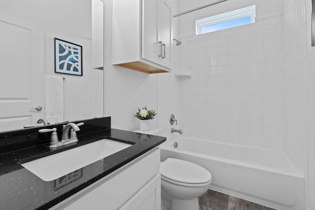 the full primary bathroom sits alongside the secondary bedrooms - featuring a contemporary vanity and shower/tub combo. | Image 27