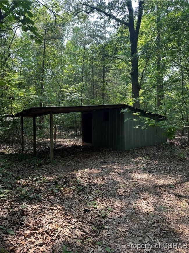 View of pole building featuring a wooded view and a carport | Image 8