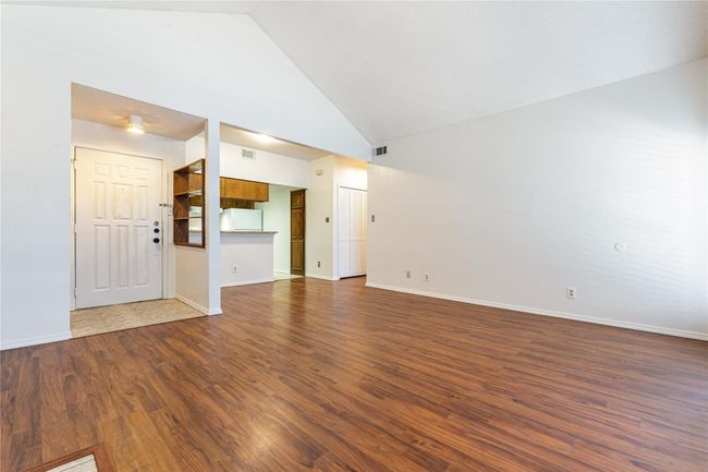 Unfurnished living room with high vaulted ceiling and dark hardwood / wood-style floors | Image 6