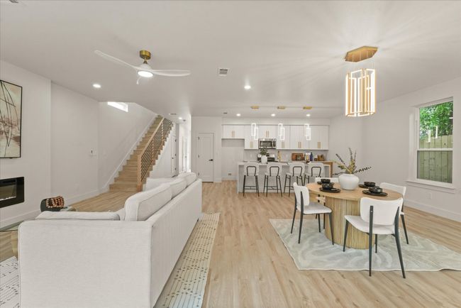 Living area with light wood-type flooring, a ceiling fan, baseboards, stairs, and recessed lighting | Image 9