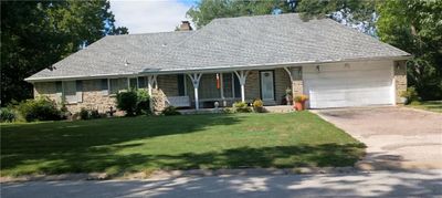 View of front of home featuring covered porch, a front yard, and a garage | Image 1