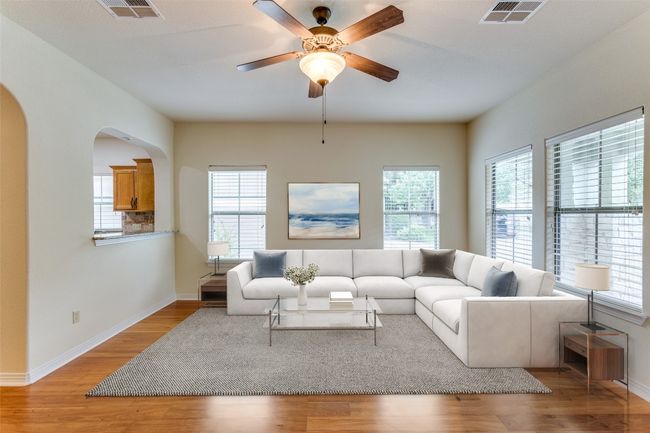 Living area featuring healthy amount of natural light, light wood finished floors, and arched walkways | Image 37