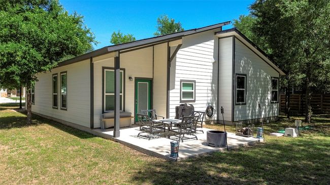 Tree-shaded backyard view of the house. | Image 6