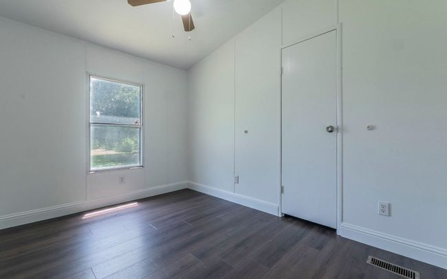Unfurnished bedroom featuring dark wood finished floors and ceiling fan | Image 14
