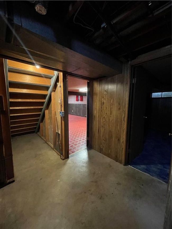 Unfinished below grade area featuring wooden walls and stairway | Image 36