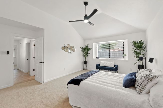 Main Bedroom featuring baseboards, vaulted ceiling, a ceiling fan, and light colored carpet | Image 24