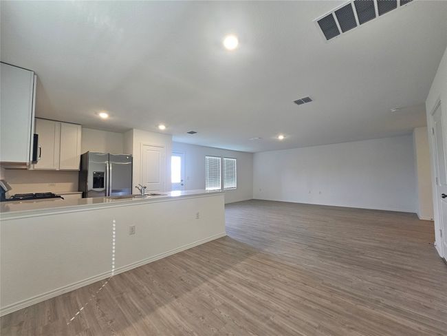 Kitchen featuring appliances with stainless steel finishes, visible vents, light wood-type flooring, and a sink | Image 10