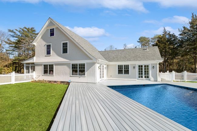Rear view of house with a fenced in pool, a yard, and french doors | Image 5