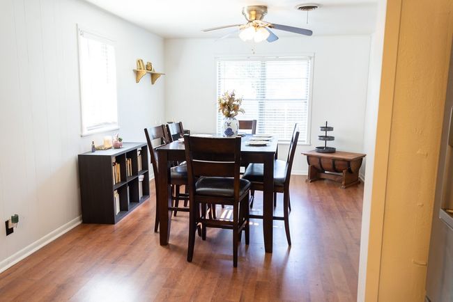 Dining area featuring healthy amount of natural light, wood finished floors, and a ceiling fan | Image 9