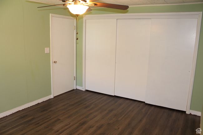 Unfurnished bedroom featuring dark wood-style floors, a closet, and a ceiling fan | Image 20